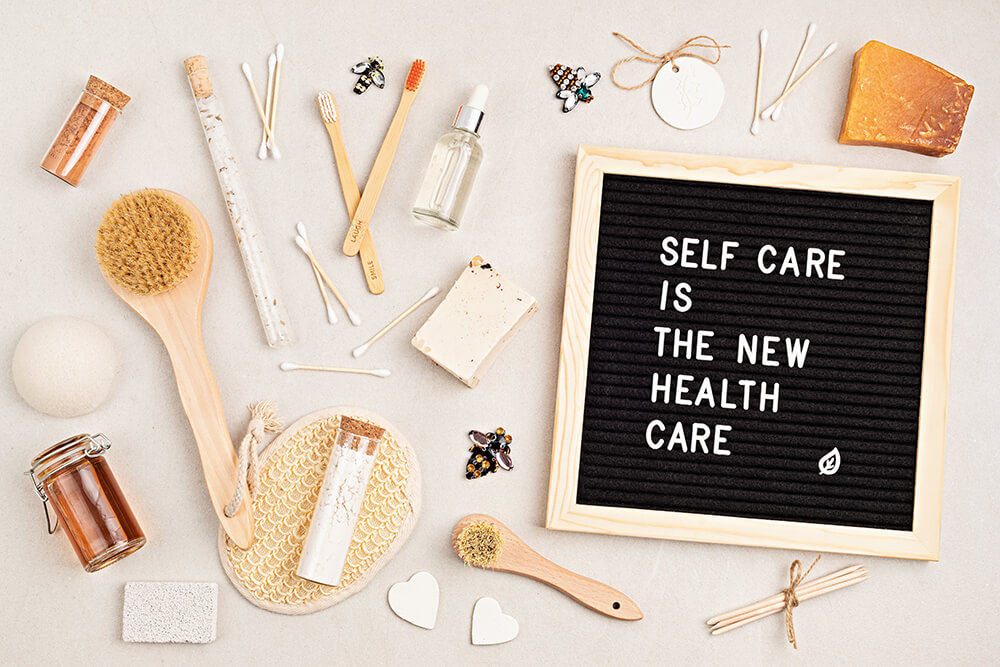 Self care is the new health care. Motivational quote on black letter board with variety of organic body and face care products. Natural homemade eco friendly beauty products concept.