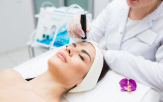 doctor-cosmetologist makes the procedure Microdermabrasion of the facial skin of a beautiful, Exfoliation, Rejuvenation And Hydratation. Cosmetology.