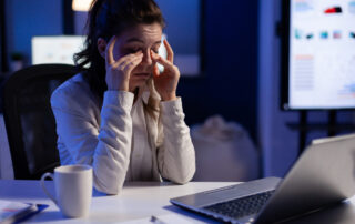 Stressed manager woman massaging tired eyes while sitting at workplace in start-up office working . Businesswoman overworking for analysing finance network to respect deadline.